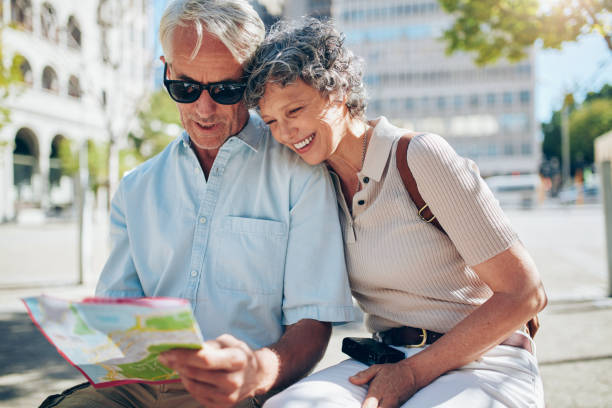 istock Happy senior tourists looking at a city map 517458334