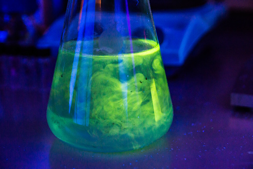 Mixing of the two chemical liquid in a flask under UV light