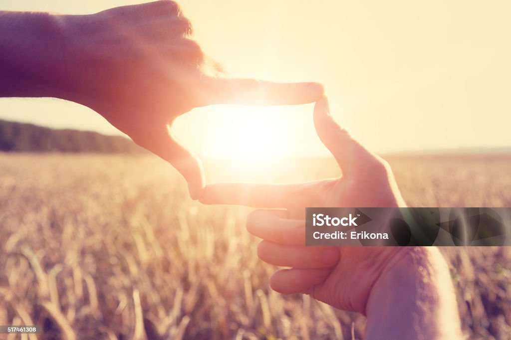 Hands framing distant sun rays Woman hands framing distant sun rays Forecasting Stock Photo