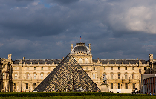 Paris, France May 26 2015 - The Louvre in late afternoon light with storm clouds behind