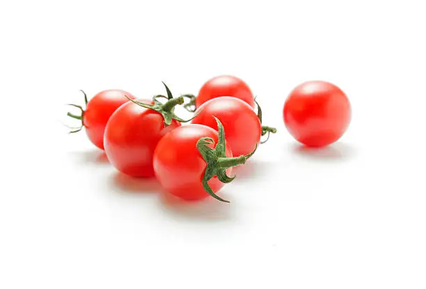 Fresh ripe cherry tomatoes closeup isolated on white background.