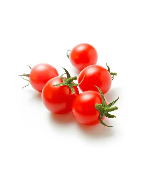Fresh ripe cherry tomatoes scattered isolated on a white background