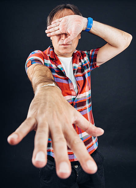 istock Man showing his fingers with eyes shut 517466331