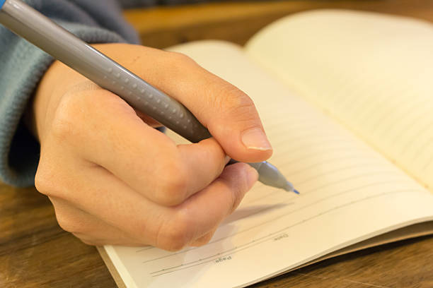 istock female hands with pen writing on ebook 517466358