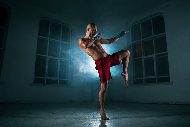 istock The young man kickboxing in blue smoke 517468096