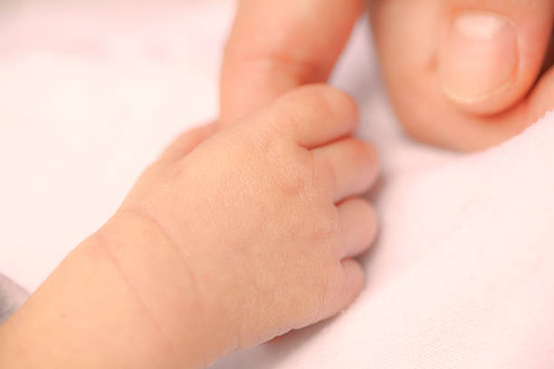 istock Baby's hand holding mother's finger 517471223