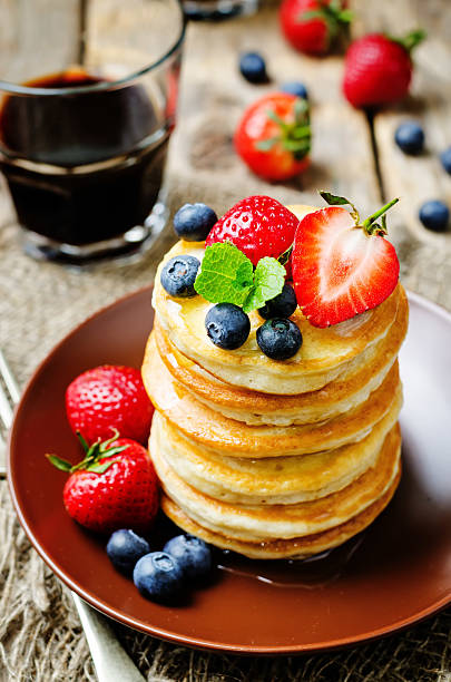 istock pancakes with honey, strawberries and blueberries 517472010