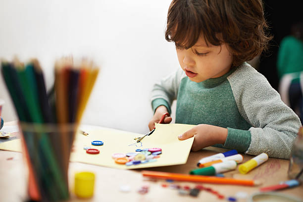 Getting creative with cutting A cute little boy doing crafts at pre-school craft stock pictures, royalty-free photos & images