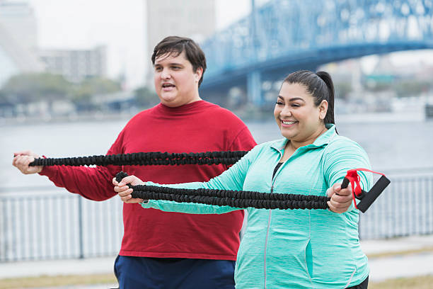 istock Overweight people exercising with resistance bands 517486878