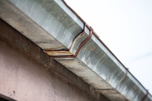 istock rusted galvanized gutter on the roof of a house. 517486983