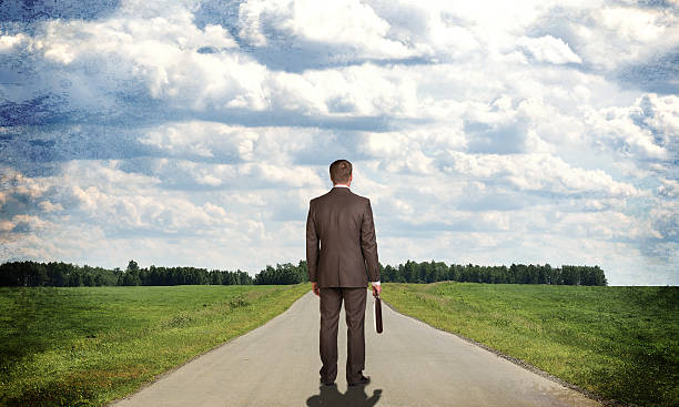 istock Businessman with briefcase standing on the road. Rear view 517487911