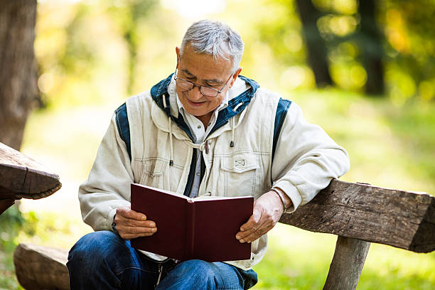 istock Senior man reading a book in park 517488481