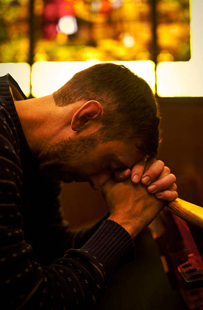 istock man praying in church 517488639