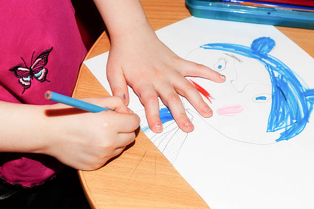 istock Child's hands drawing a picture on paper 517489892
