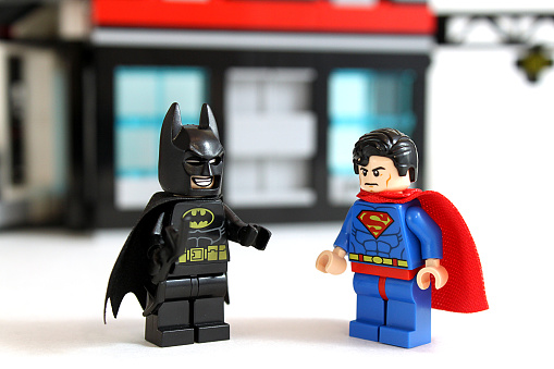 Colorado, USA - March 22, 2015: Studio shot of Lego minifigure Batman and Superman with building in background, image isolated on white.