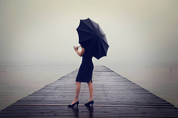 istock woman with black umbrella looking infinity in a surreal place 517494022
