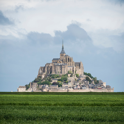 famous monastery of Mont Saint Michel with the Abbey church built above the hill during low tide in France in the Normandy
