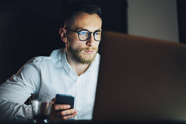 istock Portrait bearded businessman working on modern loft office at night 517496550