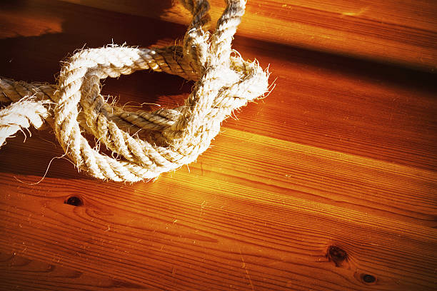 Vintage toned image of hank large ship's rope on the background of a brown wooden table. Frame made of rope.