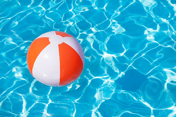 istock Colorful beach ball floating in a pool 517497062