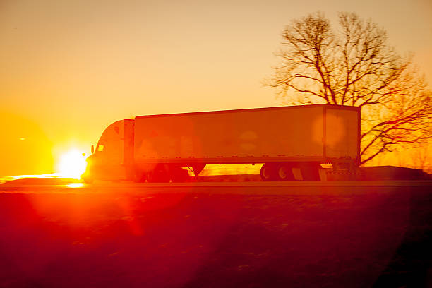 istock Tractor trailer driving down the highway at sunrise. 517497830
