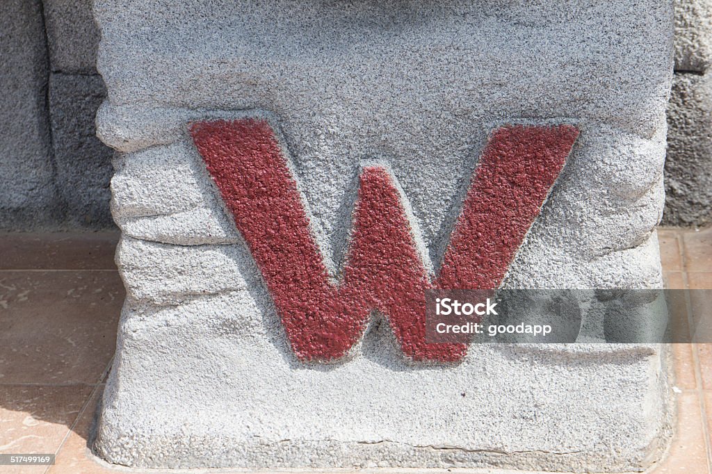 W toilet sign on stone W sign in front of toilet Adult Stock Photo