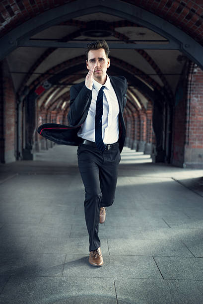 Businessman hurrying to work Businessman hurrying to work, wearing a gray suit and brown shoes. He runs because he is late ants-walking stock pictures, royalty-free photos & images