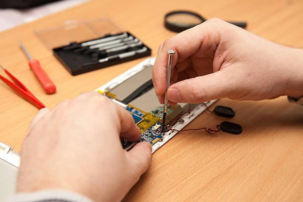 istock Master repairs the tablet computer. Top view of hands working. 517499532