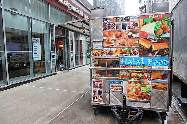 New York, United States - June 10, 2013: People walk by Halal food cart in New York. Halal food is prepared in accordance with Islamic law.