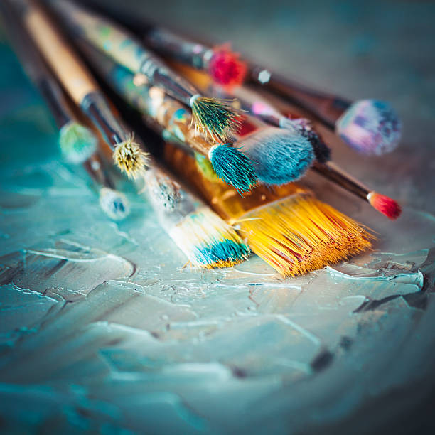 istock Paintbrushes on artist canvas covered with oil paints. 517501074