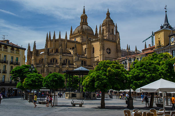 Segovia, Sapin - August 8, 2014: Beautiful picture of Segovia's Cathedral in Spain. Segovia is a city in the autonomous region of Castile and León, Spain. It is the capital of Segovia Province. Some people can be seen walking around the square that surrounds the cathedral, where many cafes and restaurants are available for locals and tourists. The Segovia Cathedral is the last Gothic cathedral built in Spain. It is considered the masterpiece of Basque-Castilian Gothic and is known as \