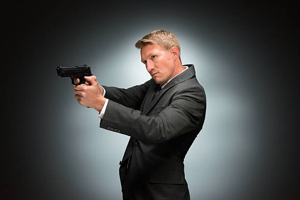 istock Businessman aiming with handgun 517501280