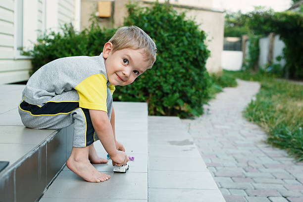 Boy sitting on stairs in back of  his house smiling Blond boy sitting on stairs in back of  his house smiling teenager couple child blond hair stock pictures, royalty-free photos & images