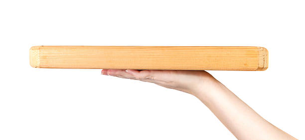 istock female hand holding a cutting board on a white background 517501416