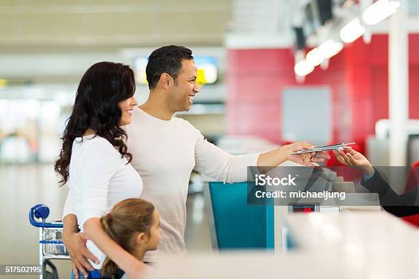 Family Handing Over Air Ticket At Airport At Check In Counter Stock Photo - Download Image Now