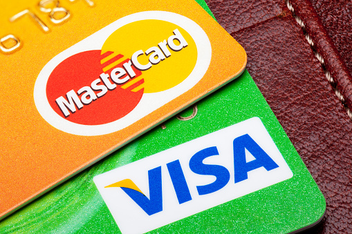 Tallinn, Estonia - September 24, 2014: Visa and Mastercard credit cards with the leather wallet on the background.