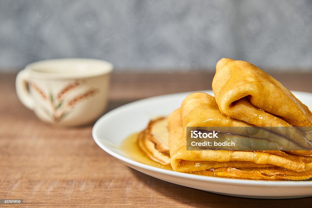 Pancakes with honey on white plate. Pancakes with honey on white plate and wooden table Backgrounds Stock Photo