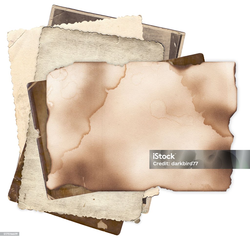 Old paper with burned edges on bunch of vintage photos Old paper with damaged and burned edges on bunch of vintage photos isolated Abstract Stock Photo