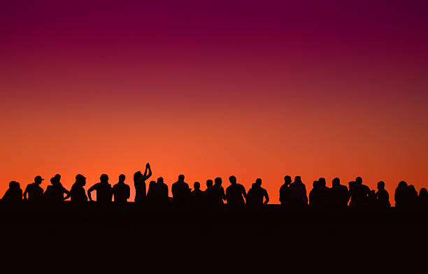 istock people silhouettes event with darkviolet and light orange sky 517516853