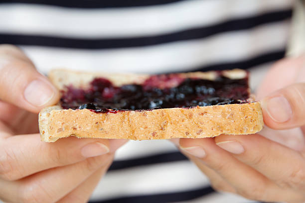 istock hand holding grape jelly sandwich 517518017