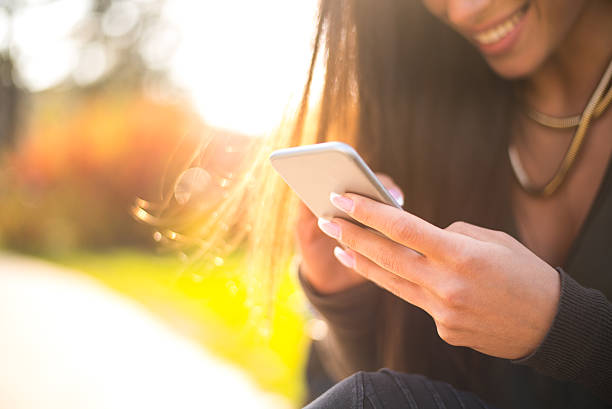 istock Beautiful woman using her smartphone outside 517520268