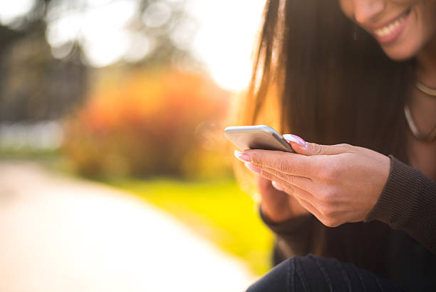 istock Beautiful woman using her smartphone outside 517520292