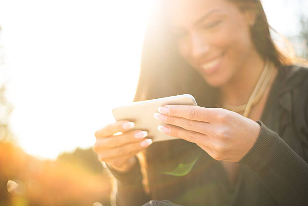 istock Beautiful woman using her smartphone outside 517520304