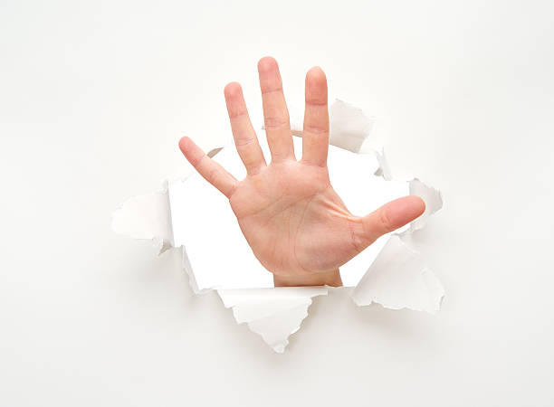 istock human hand in hole in white empty paper poster 517520965