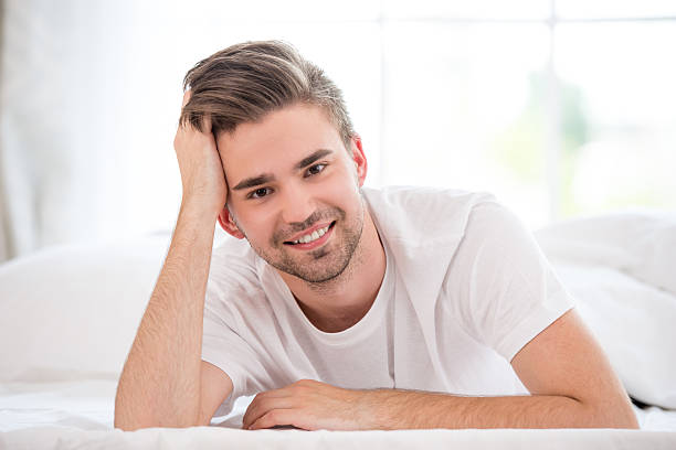istock Smiling young man in the bed 517521405