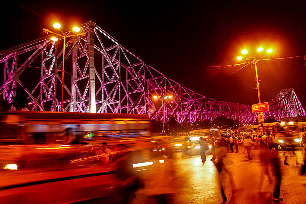 Iconic Howrah Bridge Howrah, India - April 7, 2014:Long exposure night photography of the iconic landmark Howrah Bridge(Steel bridge) taken from the Howrah Railway Station, The picture depicts the comotion of city life. kolkata night stock pictures, royalty-free photos & images