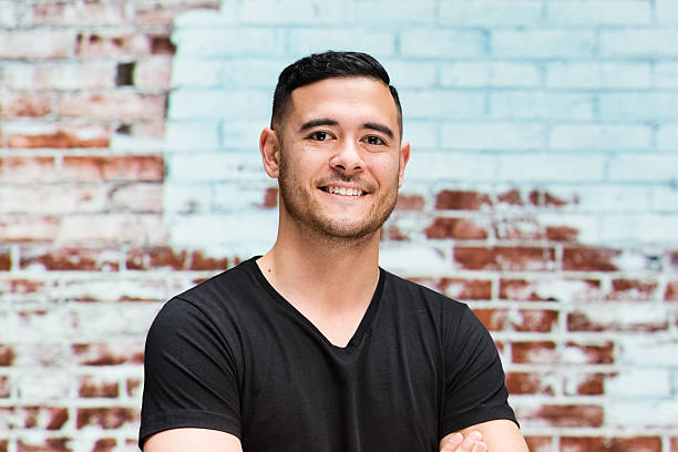 istock Smiling man in front of brick wall 517523544