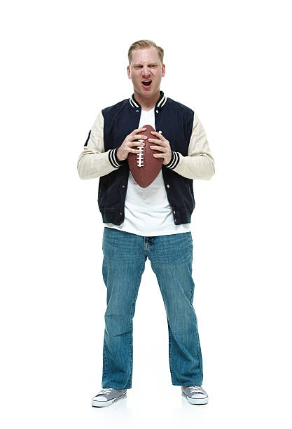 istock College student holding football and being silly 517523882