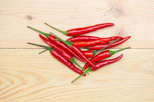 istock red chili pepper and green peppercorns on wood background. 517525532