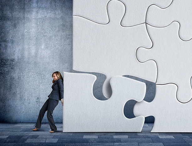 istock Businesswoman Pushing A Puzzle Piece into place 517526800